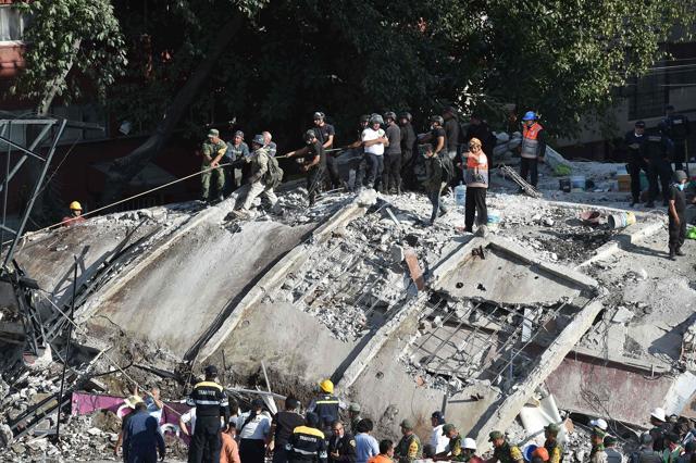 In a scene reproduced in streets across the city centre, dozens of people scrabbled with bare hands to remove rubble from atop buildings as they waited for specialized machinery to arrive. (AFP) In a scene reproduced in streets across the city centre, dozens of people scrabbled with bare hands to remove rubble from atop buildings as they waited for specialized machinery to arrive. (AFP)