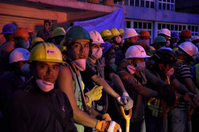 Volunteer rescuers stand by for their turn to arrive to take part in the cleanup of rubble from collapsed buildings in search of survivors, in Mexico City. (AFP)