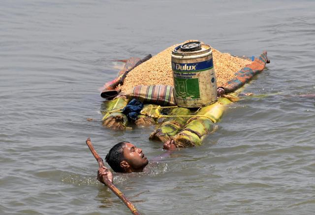 A villager carries grains on a banana raft as he shifts from a flooded village in Araria district of Bihar. (PTI File Photo) A villager carries grains on a banana raft as he shifts from a flooded village in Araria district of Bihar. (PTI File Photo)