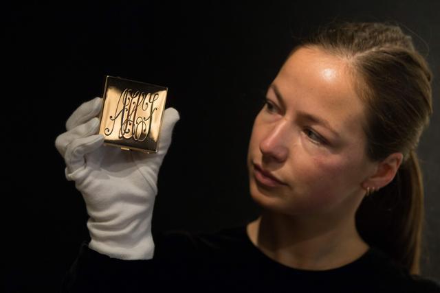 An employee holds a monogrammed powder compact Ciardetti, Firenze, 1950s, with a reserve price of £2,000 - £3,000. (AFP/Daniel Leal-Olivas)