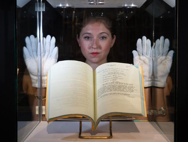 An employee poses in front of the My Fair Lady, 1964, working script with a reserve price of £30,000 - £50,000. (AFP/Daniel Leal-Olivas)