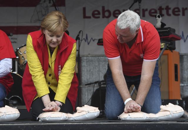 German Chancellor Angela Merkel (left) sits atop a resuscitation doll next to Dr Klaus Hahnenkamp on stage in Greifswald, Germany, on September 23, 2017. During the project week "resuscitation"' of the Medical University Greifswald, people are taught to resuscitate and Merkel attended the closing event for election campaign purposes. (AP) German Chancellor Angela Merkel (left) sits atop a resuscitation doll next to Dr Klaus Hahnenkamp on stage in Greifswald, Germany, on September 23, 2017. During the project week "resuscitation"' of the Medical University Greifswald, people are taught to resuscitate and Merkel attended the closing event for election campaign purposes. (AP)