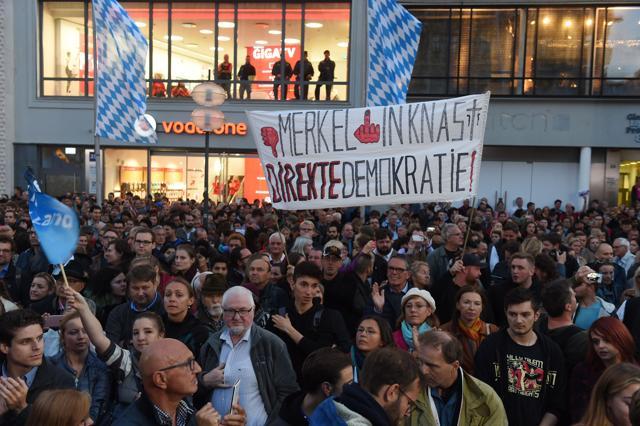 Opponents of German Chancellor Angela Merkel hold up a banner calling for her to be sent to jail as others applaud as she addresses an election campaign rally in Munich, southern Germany, on September 22, 2017. (AFP Photo) Opponents of German Chancellor Angela Merkel hold up a banner calling for her to be sent to jail as others applaud as she addresses an election campaign rally in Munich, southern Germany, on September 22, 2017. (AFP Photo)