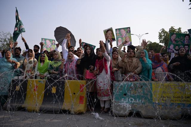 Supporters of former Pakistani premier Nawaz Sharif hold placards as they shout slogans outside an anti-corruption court where he appeared to face graft charges in Islamabad on September 26, 2017. The Supreme Court has ordered the anti-corruption watchdog, the National Accountability Bureau, to open criminal cases against Sharif, his sons - Hussain and Hassan - and his daughter Maryam. (AFP)
