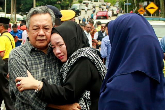 Nik Azlan Nik Abdul Kadir (L), father of one of the victims comforts his wife outside the Darul Quran Ittifaqiyah religious school in Kuala Lumpur on September 14, 2017. (AFP) Nik Azlan Nik Abdul Kadir (L), father of one of the victims comforts his wife outside the Darul Quran Ittifaqiyah religious school in Kuala Lumpur on September 14, 2017. (AFP)