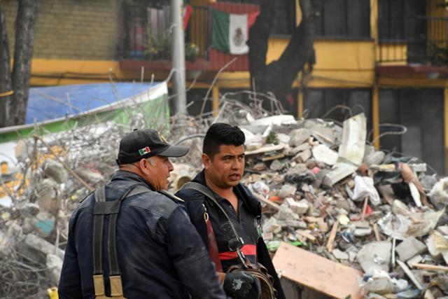 Mexican firefighters remove the debris from a multi-family building that collapsed during the 7.1-magnitude earthquake beside the Tlalpan road in Mexico City on September 26, 2017. A week after an earthquake that killed more than 300 people, a shaken Mexico was torn Tuesday between trying to get back to normal and keeping up an increasingly hopeless search for survivors. (AFP) Mexican firefighters remove the debris from a multi-family building that collapsed during the 7.1-magnitude earthquake beside the Tlalpan road in Mexico City on September 26, 2017. A week after an earthquake that killed more than 300 people, a shaken Mexico was torn Tuesday between trying to get back to normal and keeping up an increasingly hopeless search for survivors. (AFP)