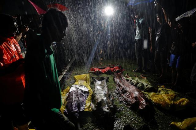 People gather under heavy rain around bodies of Rohingya refugees after a boat with people fleeing from Myanmar capsized off Inani Beach near Cox's Bazar, Bangladesh. (Reuters) People gather under heavy rain around bodies of Rohingya refugees after a boat with people fleeing from Myanmar capsized off Inani Beach near Cox's Bazar, Bangladesh. (Reuters)