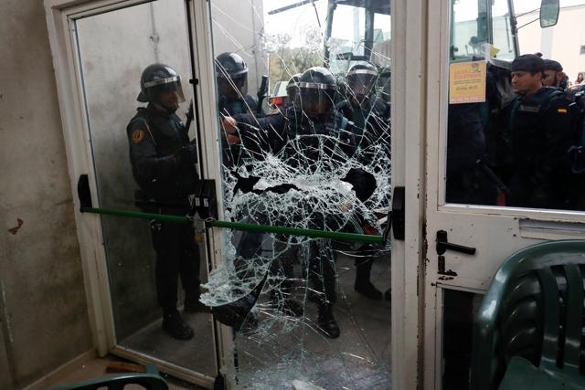 Spanish Civil Guard officers break through a door at a polling station for the banned independence referendum where Catalan President Carles Puigdemont was supposed to vote in Sant Julia de Ramis, Spain October 1, 2017. (REUTERS) Spanish Civil Guard officers break through a door at a polling station for the banned independence referendum where Catalan President Carles Puigdemont was supposed to vote in Sant Julia de Ramis, Spain October 1, 2017. (REUTERS)
