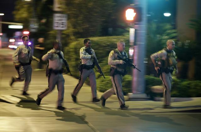 Police run to cover at the scene of a shooting near the Mandalay Bay resort and casino on the Las Vegas Strip. (AP Photo)