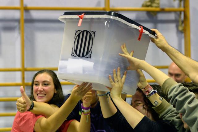 People hold a ballot box at a polling station in Barcelona, on October 01, 2017, following a referendum on independence for Catalonia banned by Madrid. (AFP)