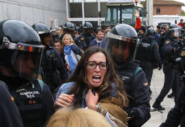 People clash with Spanish Guardia Civil guards outside a polling station in Sant Julia de Ramis, where Catalan president was supposed to vote. (AFP Photo) People clash with Spanish Guardia Civil guards outside a polling station in Sant Julia de Ramis, where Catalan president was supposed to vote. (AFP Photo)