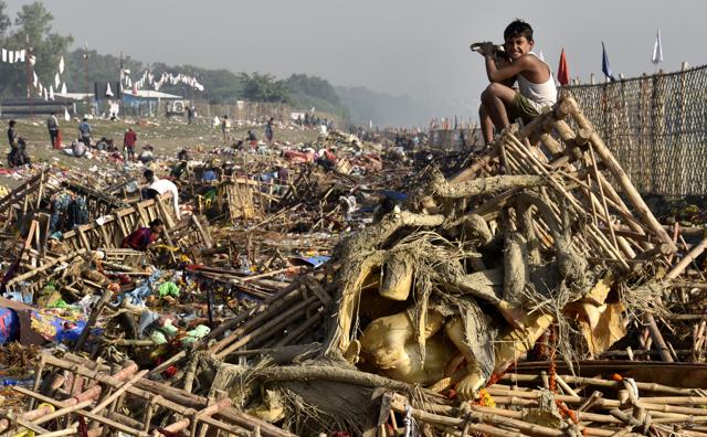 A child sits on a heap of debris on Yamuna bank after Durga Puja celebrations. (Arvind Yadav/HT PHOTO) A child sits on a heap of debris on Yamuna bank after Durga Puja celebrations. (Arvind Yadav/HT PHOTO)