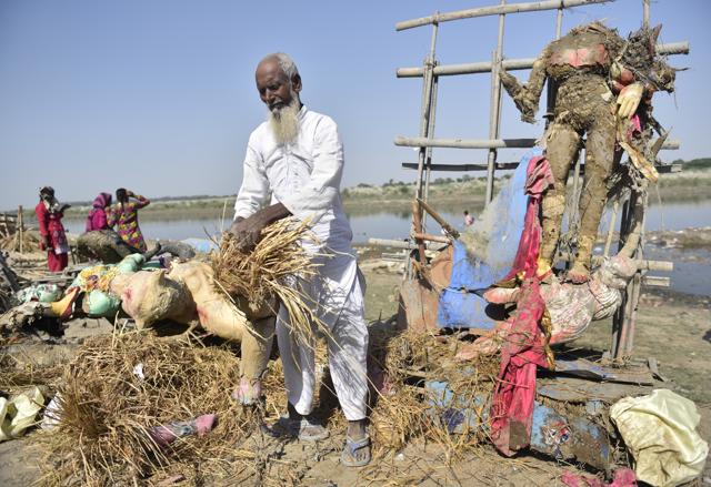 A local dismantles idols that were immersed in Yamuna after culmination of Durga Puja. (Sanchit Khanna/HT PHOTO)