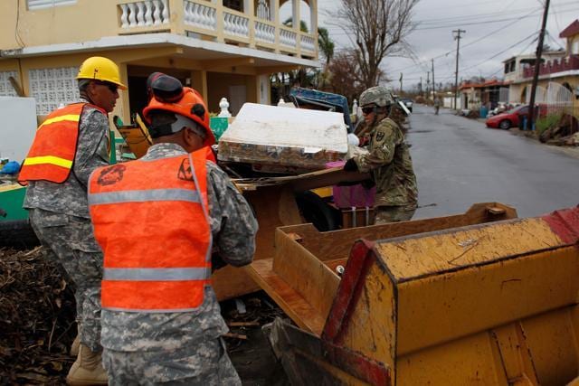 Puerto Rico National Guard personnel load debris into a bulldozer in the aftermath of Hurricane Maria in Humacao, Puerto Rico on October 2, 2017. (AFP)