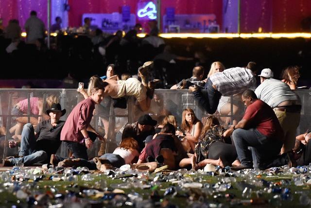People scramble for shelter at the Route 91 Harvest country music festival after apparent gun fire was heard. (AFP Photo)