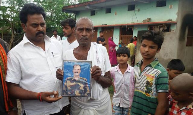 Family members show a photograph of slain BSF officer Brij Kishore Yadav who died in Jammu and Kashmir on Tuesday. (HT Photo) Family members show a photograph of slain BSF officer Brij Kishore Yadav who died in Jammu and Kashmir on Tuesday. (HT Photo)