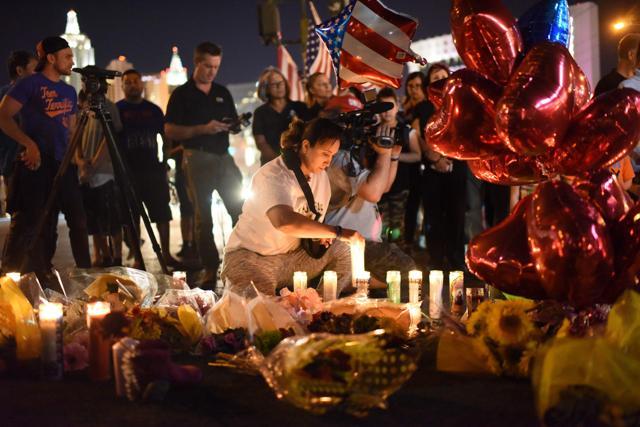 A woman lights a candle at a makeshift memorial near the Mandalay Hotel on the Las Vegas Strip, in Las Vegas, Nevada. (AFP Photo)