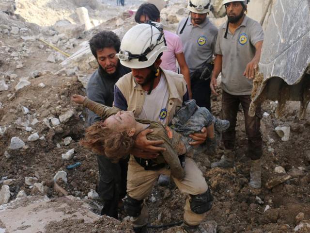 A Syrian civil defence volunteer, known as the White Helmets, holds the body of a child after he was pulled from the rubble following a government forces air strike on the rebel-held neighbourhood of Karm Homad in the northern city of Aleppo. (AFP File Photo)
