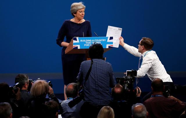 A member of the audience hands a P45 form (termination of employment tax form) to Britain's Prime Minister Theresa May as she addresses the Conservative Party conference in Manchester on October 4, 2017. (Reuters) A member of the audience hands a P45 form (termination of employment tax form) to Britain's Prime Minister Theresa May as she addresses the Conservative Party conference in Manchester on October 4, 2017. (Reuters)