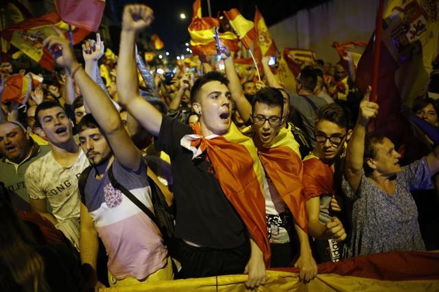 Anti-independence demonstrators shout slogans and wave Spanish flags in support of Spain's security forces in front of a Guardia Civil barracks in Sant Boi de LLobregat, in the outskirts of Barcelona, Spain. (AP Photo)