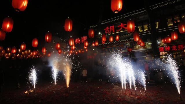 People watch fireworks to celebrate the start of the Chinese New Year in front of a restaurant in Beijing on January 31, 2014. (Reuters)