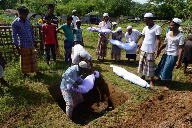 Bangladeshi volunteers bury Rohingya refugees children, who died when their boat capsized when crossing from Myanmar into Bangladesh, at a graveyard in Sha Porir Dwip in Teknaf on October 9, 2017. (AFP Photo)