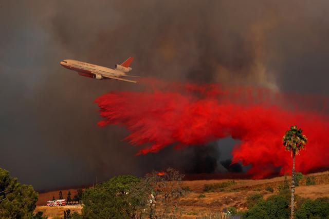 A DC-10 aircraft drops fire retardant on a wind driven wildfire in Orange, California, U.S., October 9, 2017. (REUTERS) A DC-10 aircraft drops fire retardant on a wind driven wildfire in Orange, California, U.S., October 9, 2017. (REUTERS)