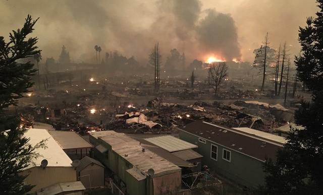 In this Monday, Oct. 9, 2017, photo, the Fountain Grove Inn burns in the distance as the devastated Journey's End mobile home park smolders in Santa Rosa, Calif. (AP) In this Monday, Oct. 9, 2017, photo, the Fountain Grove Inn burns in the distance as the devastated Journey's End mobile home park smolders in Santa Rosa, Calif. (AP)