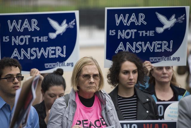 People hold up signs during a protest calling for the Trump administration to continue diplomacy with Iran near the White House in Washington, DC. (AFP Photo)