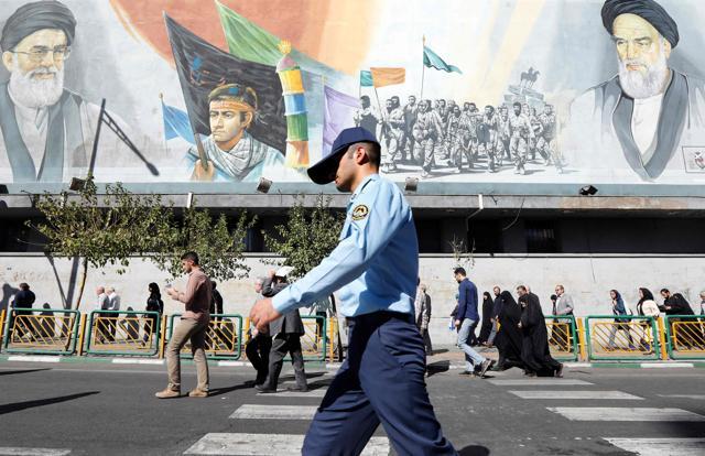 A member of the Iranian army walks past pictures of Iranian supreme leader Ayatollah Ali Khamenei (top left) and of late Iranian supreme leader Ayatollah Ruhollah Khomeini (top right), in Tehran. (AFP Photo) A member of the Iranian army walks past pictures of Iranian supreme leader Ayatollah Ali Khamenei (top left) and of late Iranian supreme leader Ayatollah Ruhollah Khomeini (top right), in Tehran. (AFP Photo)