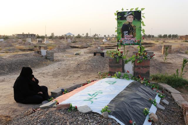 An Iraqi woman visits the grave of a relative, who was killed during battles with Islamic State (IS) group fighters, at a graveyard in Dhuluiyah. (AFP)