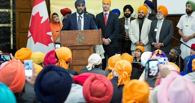 Canadian Minister of National Defence Harjit Sajjan speaks at a Vaisakhi celebration on Parliament Hill in Ottawa and Prime Minister Justin Trudeau looks on. (Photo Courtesy PMO Canada) Canadian Minister of National Defence Harjit Sajjan speaks at a Vaisakhi celebration on Parliament Hill in Ottawa and Prime Minister Justin Trudeau looks on. (Photo Courtesy PMO Canada)