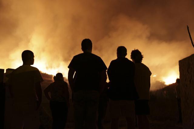 People watch a wildfire raging near houses in the outskirts of Obidos, Portugal, in the early hours of Monday, Oct. 16 2017. (AP) People watch a wildfire raging near houses in the outskirts of Obidos, Portugal, in the early hours of Monday, Oct. 16 2017. (AP)
