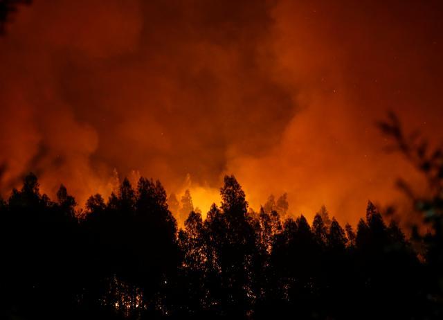 Smoke and flames from a forest fire are seen near Lousa, Portugal, October 16, 2017. (REUTERS) Smoke and flames from a forest fire are seen near Lousa, Portugal, October 16, 2017. (REUTERS)
