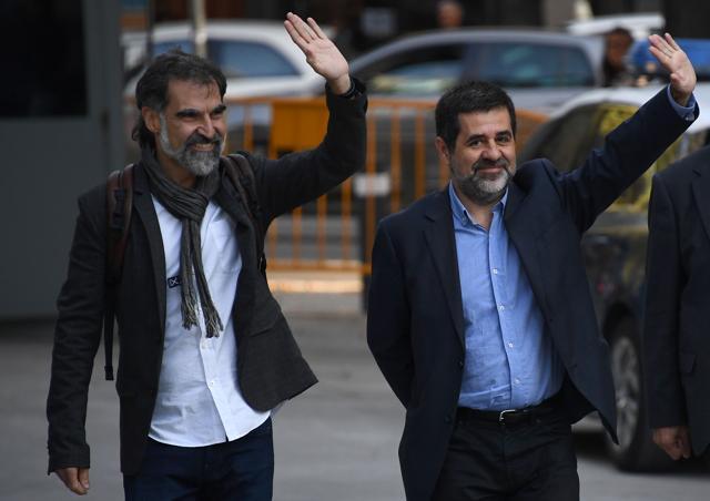Catalan National Assembly (ANC) president Jordi Sanchez (C), and Pro-independence Catalan Omnium cultural language association president Jordi Cuixart (L) wave as they arrive at the High Court in Madrid on October 16, 2017. (AFP) Catalan National Assembly (ANC) president Jordi Sanchez (C), and Pro-independence Catalan Omnium cultural language association president Jordi Cuixart (L) wave as they arrive at the High Court in Madrid on October 16, 2017. (AFP)