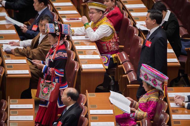 Delegates, some wearing an ethnic minority outfits, listen to an address by Chinese President Xi Jinping on October 18, 2017. (AFP Photo)