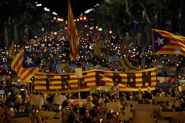 People hold a giant Estelada (pro-independence Catalan flag) reading "Freedom" during candle-lit demonstration in Barcelona against the arrest of two Catalan separatist leaders on October 17, 2017. (AFP)