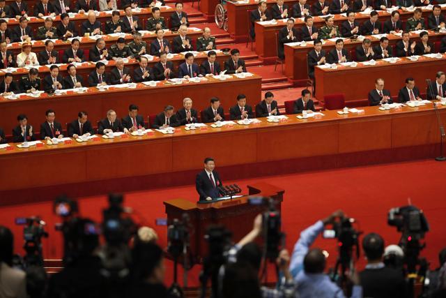 Journalists film delegates applauding Chinese President Xi Jinping delivering a speech at the opening ceremony of the 19th Party Congress at the Great Hall of the People in Beijing, on October 18. (AP Photo)