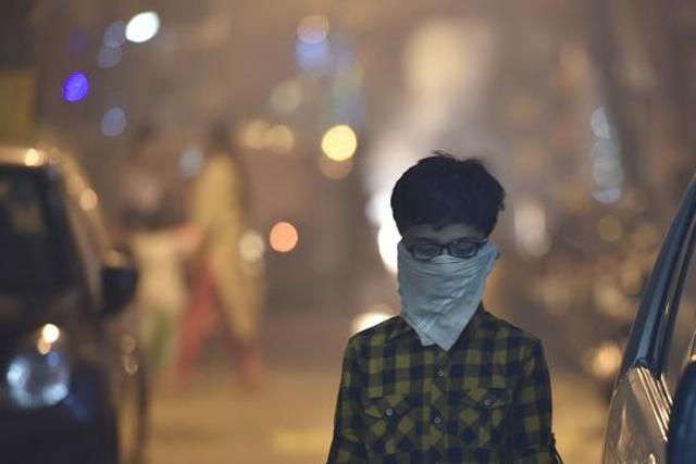 A child protects his face amid heavy smog due to bursting of firecrackers despite the ban imposed by the Supreme Court of India to control the air pollution following Diwali celebrations. (HT FILE PHOTO) A child protects his face amid heavy smog due to bursting of firecrackers despite the ban imposed by the Supreme Court of India to control the air pollution following Diwali celebrations. (HT FILE PHOTO)