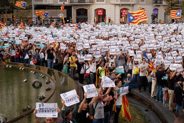 Protesters wave pro-independence Catalan Estelada flags along with signs calling for the release of two separatist leaders during a demonstration in Barcelona on October 21. (AFP)