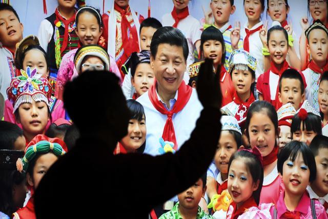 A Chinese man waves in front of a picture showing President Xi Jinping with children on display at an exhibition highlighting China's achievements under five years of his leadership at the Beijing Exhibition Hall in the capital city, where the Communist Party congress on October 23, 2017. (AP) A Chinese man waves in front of a picture showing President Xi Jinping with children on display at an exhibition highlighting China's achievements under five years of his leadership at the Beijing Exhibition Hall in the capital city, where the Communist Party congress on October 23, 2017. (AP)