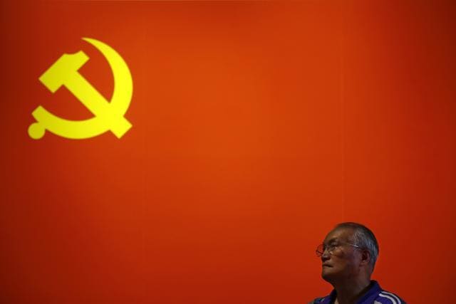 A Chinese man stands watch before a Communist flag on display at an exhibition highlighting China's achievements under five years of the leadership of President Xi Jinping at the Beijing Exhibition Hall in the capital city where the Communist Party congress is being held on October 23, 2017. (AP) A Chinese man stands watch before a Communist flag on display at an exhibition highlighting China's achievements under five years of the leadership of President Xi Jinping at the Beijing Exhibition Hall in the capital city where the Communist Party congress is being held on October 23, 2017. (AP)