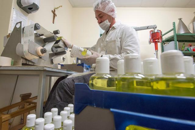An employee manufacturing cosmetics products uses a labelling machine as he packages products at the Saint-Vincent abbey in Chantelle. (AFP) An employee manufacturing cosmetics products uses a labelling machine as he packages products at the Saint-Vincent abbey in Chantelle. (AFP)