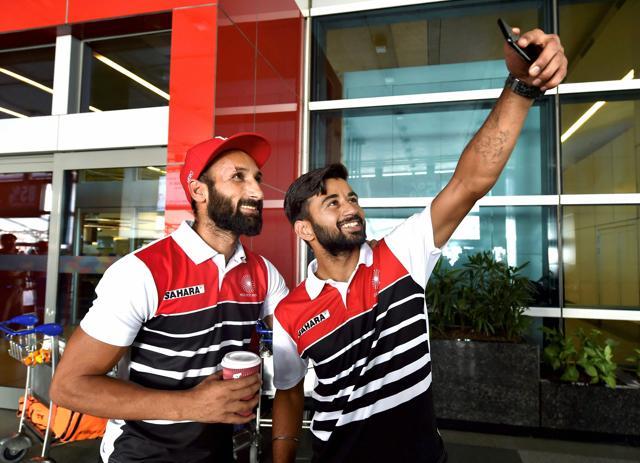 Indian hockey team captain Manpreet Singh takes a selfie with teammate Sardara Singh at IGI Airport in New Delhi on Monday. (PTI)