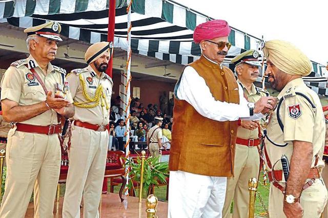 Governor VP Singh Badnore felicitates a policeman for meritorious service as DGP Suresh Arora (left) looks on, at Phillaur on Monday. (HT Photo) Governor VP Singh Badnore felicitates a policeman for meritorious service as DGP Suresh Arora (left) looks on, at Phillaur on Monday. (HT Photo)