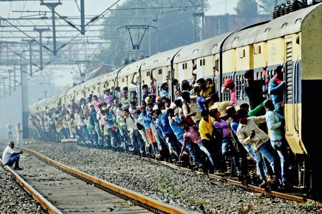 Patna: Passengers hang from the coaches of an over crowded train while traveling home for the Chhath Puja festival near Parsa Bazar railway station in Patna. (PTI) Patna: Passengers hang from the coaches of an over crowded train while traveling home for the Chhath Puja festival near Parsa Bazar railway station in Patna. (PTI)