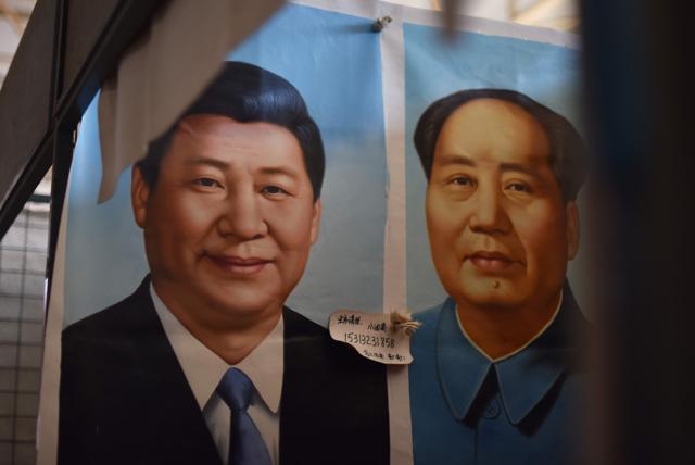 Painted portraits of Chinese President Xi Jinping (L) and late communist leader Mao Zedong at a market in Beijing on September 19, 2017. (AFP File Photo) Painted portraits of Chinese President Xi Jinping (L) and late communist leader Mao Zedong at a market in Beijing on September 19, 2017. (AFP File Photo)