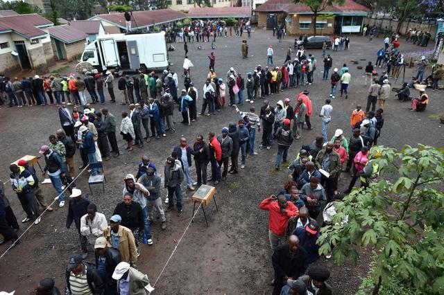 Residents queue to cast their votes at a polling station in Moi Primary School in the central business district of Nairobi on October 26, 2017, as voting in Kenya's repeat presidential poll kicked off on a low turn-out at some polling stations. (AFP)