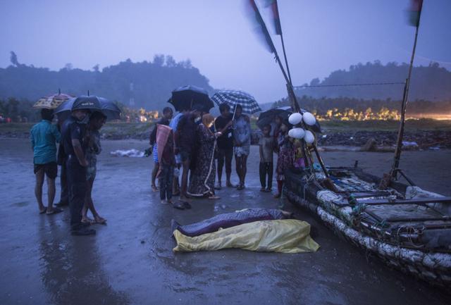 People gather around bodies of Rohingya Muslim refugees, on the shore of Inani beach, near Cox's Bazar on September 28. (AFP) People gather around bodies of Rohingya Muslim refugees, on the shore of Inani beach, near Cox's Bazar on September 28. (AFP)