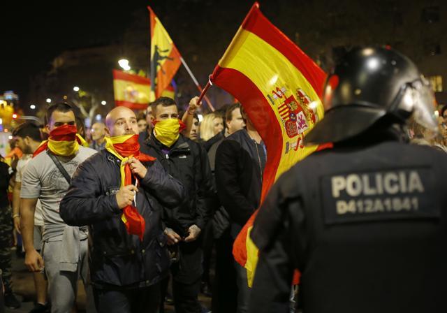 Holding Spanish flags, demonstrators confront Catalan police as they are prevented from moving forward during a march against the unilateral declaration of independence. (AP Photo) Holding Spanish flags, demonstrators confront Catalan police as they are prevented from moving forward during a march against the unilateral declaration of independence. (AP Photo)